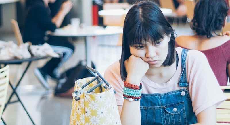 Girl with no lunch sitting at school table