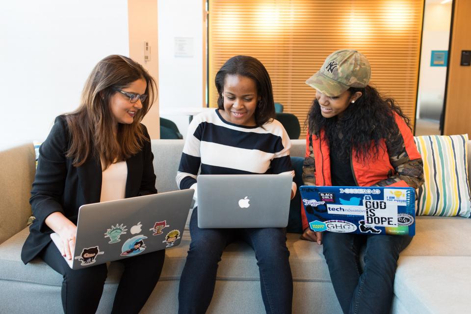 Three people with laptops looking at new website