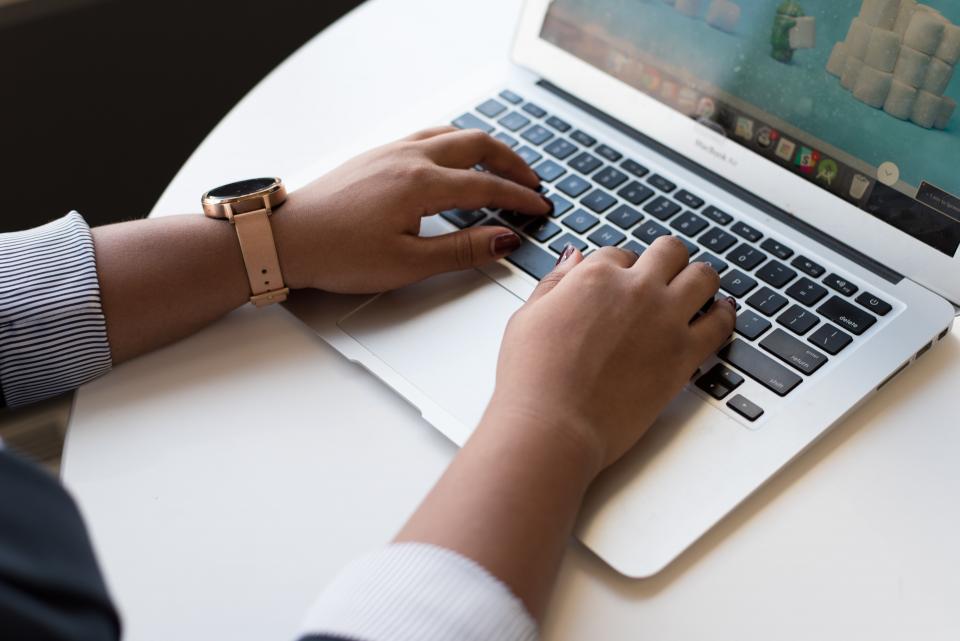 Person typing on laptop keyboard