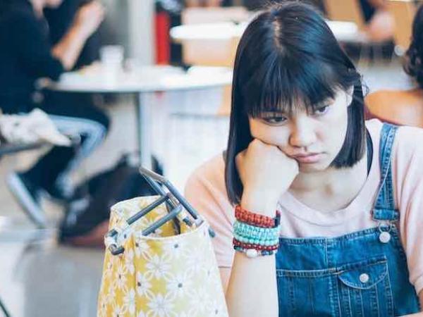 Girl with no lunch sitting at school table