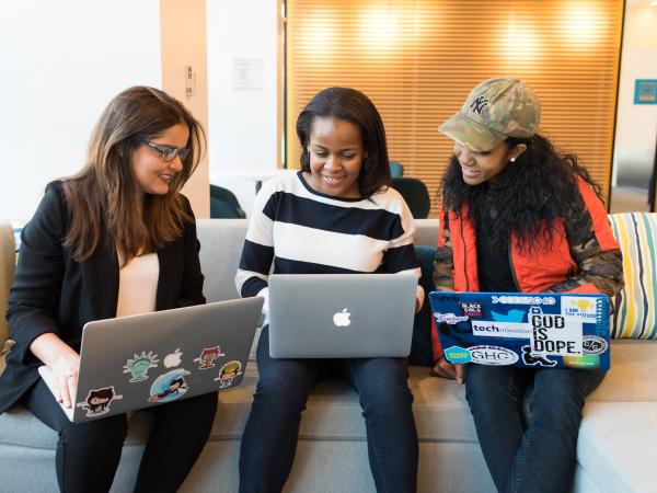 Three people with laptops looking at new website