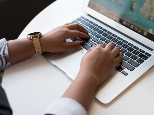 Person typing on laptop keyboard