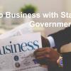Man with newspaper and Do business with state governments text